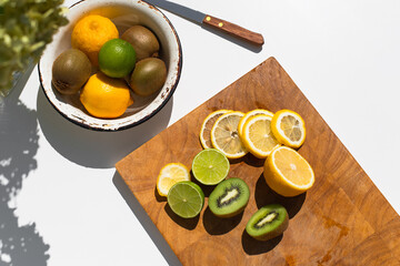 Photo of ingridients for refreshing summer lemonade cocktail  with fresh citrus lime lemon and green mint and cocktail bar tools outdoors with white background flat lay style
