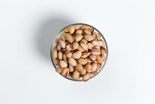 Pistachios In A Glass Cup On A White Background. Close-up.