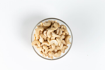 cashews in a glass cup on a white background. Close-up.