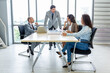 © Pornsak - Businesspeople discussing together in the conference room during meeting at the office.