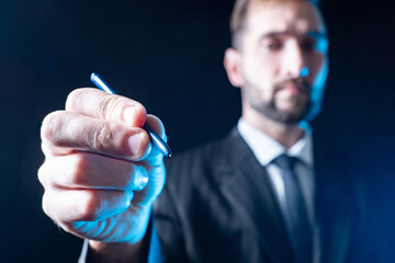 Poster - the businessman holds a stylus in his hand. close-up of a man's hand with a stylus. a man writes wit