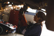 © Wavebreak Media - Mixed race female car mechanic wearing overalls, using angle grinder