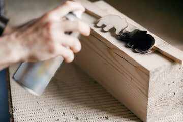 Wall Mural - Man holding paint spray and painting wood