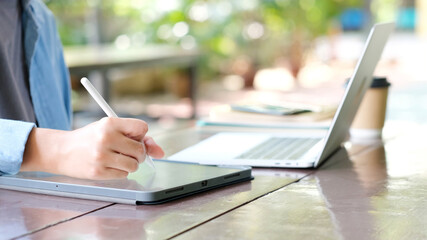 Close up of man hand using digital tablet for working at home, online study, telecommunication