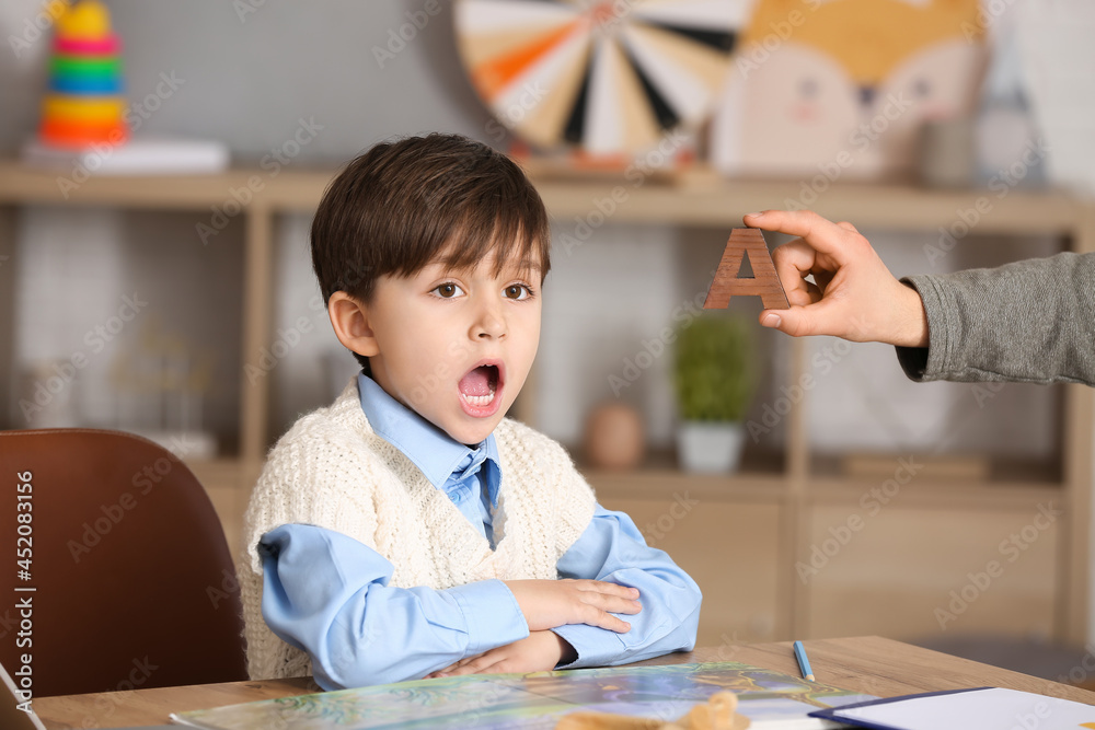 Little boy training pronounce letter A at speech therapist office