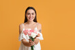 © Pixel-Shot - Young woman with beautiful carnation flowers on color background