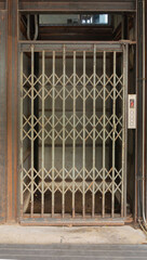 A classic old elevator lift with collapsible gate in hotel. Interior architectural element. Antique and vintage design.