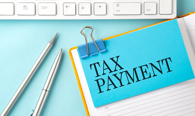 Poster - TAX PAYMENT text on sticker on the blue background with pen and keyboard