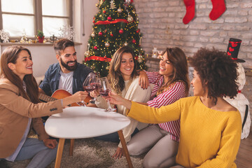 Wall Mural - Friends singing Christmas songs and drinking wine