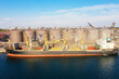 © Elena - Loading grain into holds of sea cargo vessel through an automatic line in seaport from silos of grain storage. Bunkering of dry cargo ship with grain