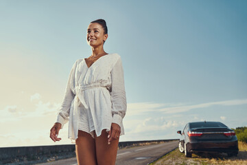 Wall Mural - Cheerful lady looking out for passing cars on road