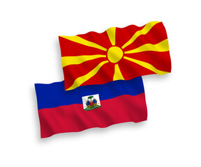 National vector fabric wave flags of Republic of Haiti and North Macedonia isolated on white background. 1 to 2 proportion.