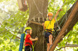 © Angelov - Cute children. Boy and girl climbing in a rope playground structure at adventure park