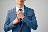 Fototapeta Pomosty - business man in a suit straightens his tie professional office