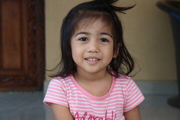 Beautiful Asian Little Girl looking at Camera and smile 