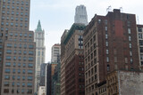 Fototapeta Uliczki - Old Buildings and Skyscrapers along a Street in Lower Manhattan of New York City