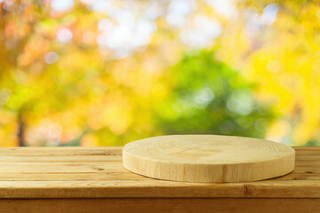 Wall Mural - Empty wooden log on rustic table over blurred autumn leaves background.  Thanksgiving or Halloween holiday  mock up for design and product display.