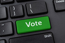 Vote Green Key On A Black Pc Keyboard. Online Participation In Elections, Internet Voting And E-voting Concepts. Computer Notebook Enter Key With Vote Word. Message On The Enter Button Of Keyboard.