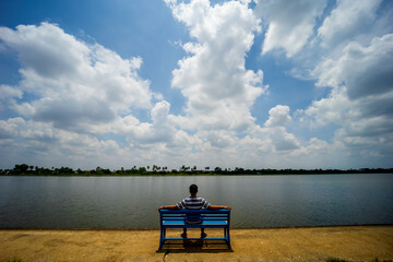Wall Mural - clear blue sky with white fluffy clouds in the daytime over the river