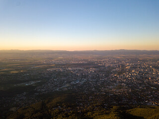 Wall Mural - Scenic view of a town surrounded by lush nature during sunset