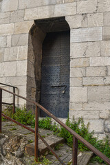 Canvas Print - Studded entrance door of one of the towers of Porta Soprana, medieval city gate of Genoa, Liguria, Italy