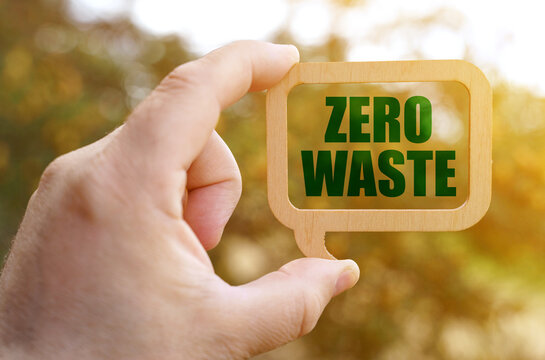A man holds a sign inside which the inscription - Zero waste
