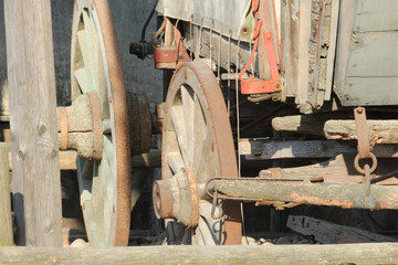 Sticker - Closeup shot of an old wooden cart with metal wheels on a sunny day