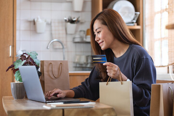 A woman using laptop computer and credit card for online shopping at home