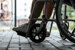 © Aliaksandr Marko - Close-up of a leg on a wheelchair in the street. Disease recognition, disability, serious condition.