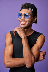 Wall Mural - Portrait of cheerful transgender male in black t-shirt, blue sunglasses. Latin american trans gender