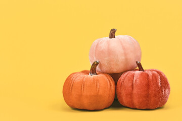 Wall Mural - Orange pumpkin decorations made from velvet fabric in corner of yellow background