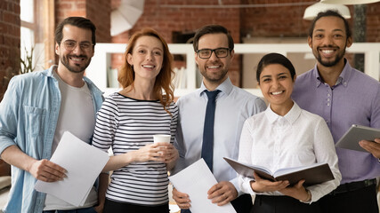 Canvas Print - Team of diverse businesspeople multiethnic colleagues standing in modern office smile look at camera. Career advance, leadership, racial equality, professional company corporate staff portrait concept