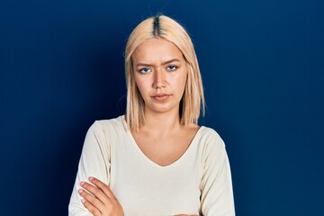 Poster - Beautiful blonde woman wearing casual sweater skeptic and nervous, disapproving expression on face with crossed arms. negative person.