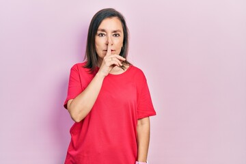 Sticker - Middle age hispanic woman wearing casual clothes asking to be quiet with finger on lips. silence and secret concept.