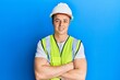 © Krakenimages.com - Handsome young man wearing safety helmet and reflective jacket happy face smiling with crossed arms looking at the camera. positive person.