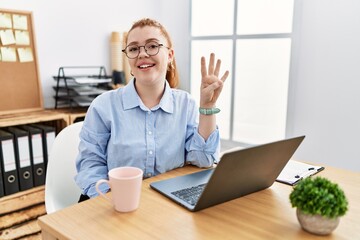 Poster - Young redhead woman working at the office using computer laptop showing and pointing up with fingers number four while smiling confident and happy.