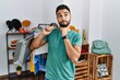 © Krakenimages.com - Young handsome man with beard holding shopping bags at retail shop with hand on chin thinking about question, pensive expression. smiling with thoughtful face. doubt concept.