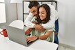 © Krakenimages.com - Young latin couple using laptop and drinking coffee at home.