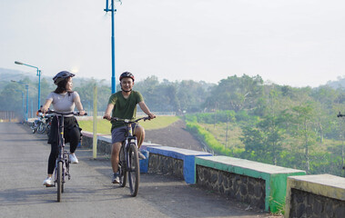 young asian couple ride bicycle together in the morning