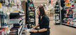 © pavel siamionov - Portrait of young woman choosing school stationery in supermarket.