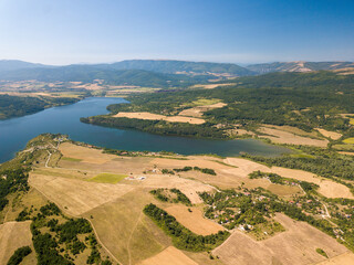 Wall Mural - Aerial view of a blue lake, agricultural fields and mountains under a blue clear sky