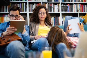 Wall Mural - College, study, university and education concept. Group of tired students learning in library