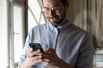 Wall Mural - close up of happy young caucasian businessman look at cellphone screen talk speak on video webcam ca