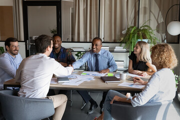 Wall Mural - Smiling multiethnic business partners shake hands close deal make agreement at meeting in office. Happy African American businessman handshake get acquainted with colleague. Partnership concept.