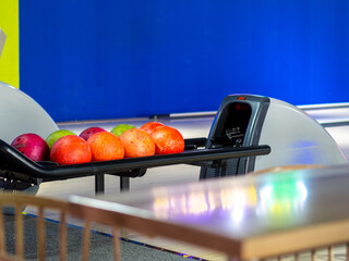 Poster - Closeup of colorful bowling balls on a track under the lights in an arena