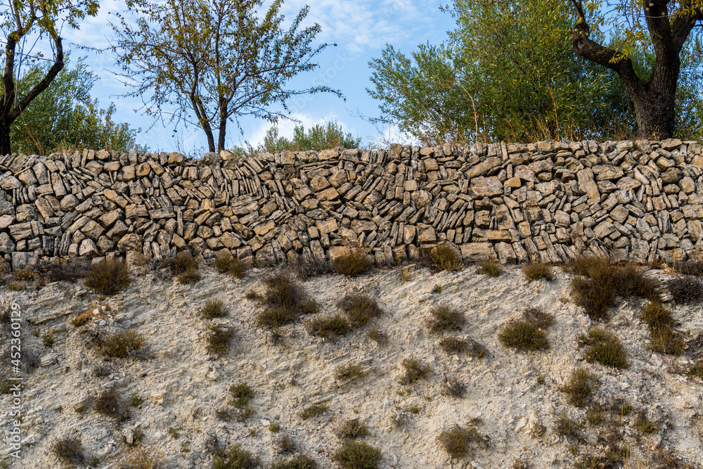 Wall built with stacked stones of different sizes and shapes, to ...