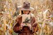Style woman with gift box on corn field in autumn time season