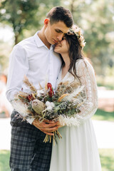 Wall Mural - Happy family of bride and groom, Smiling newlyweds together in wedding suits, in the park on a sunny day, Concept of love and happiness