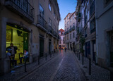 Fototapeta Uliczki - Life on the streets of the old city at sunset. Evening in the center of the old city of Lisbon. Alfama. Portugal.