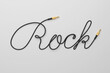 © Kuzmick - Cable with audio connector Rock word shaped on gray background. 3d rendering.
